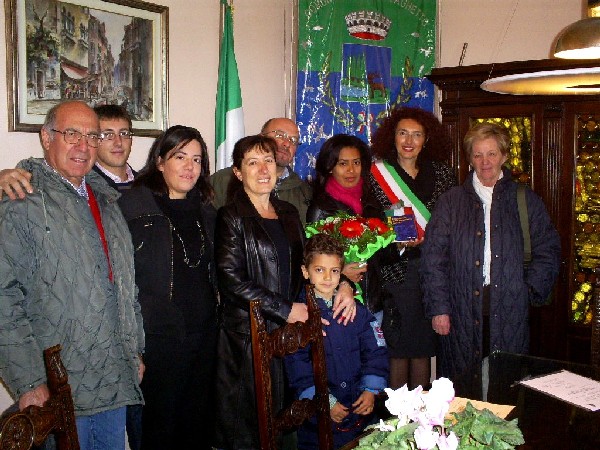 Immagine della Signora De Oliveira con i propri famigliari e accanto al Sindaco Ferrario