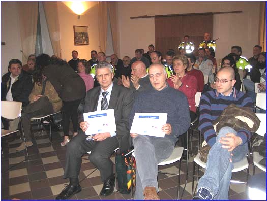 Immagine del pubblico, in primo piano due volontari con l'attestato